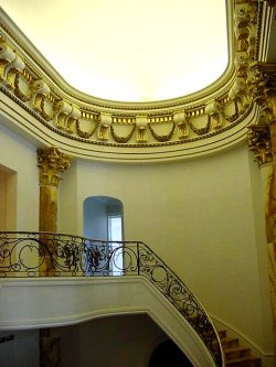 Dramatic
                  plaster stairway features elliptical dome ceiling,
                  massive cornice with corbels