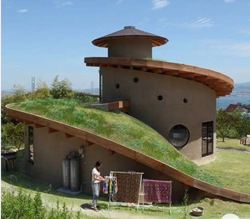 A spiral house with a green roof
